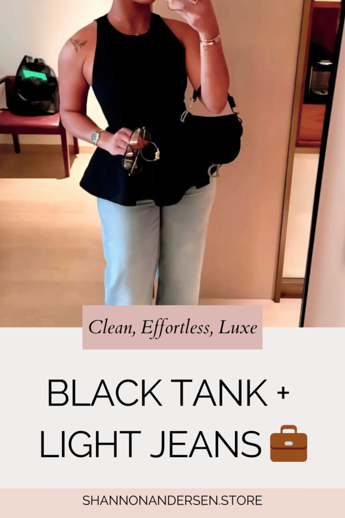 A woman in a fitted black sleeveless top paired with light-wash wide-leg jeans, neutral open-toe sandals, a slick low bun, and a black mini shoulder bag. A clean minimalist outfit with a polished vibe.